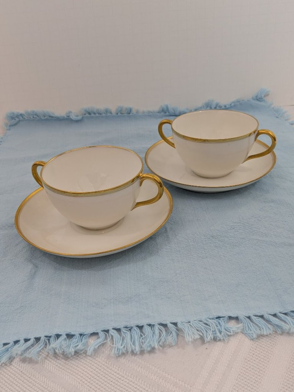 Pair of Haviland bouillon cups and saucers - white porcelain with gold rim